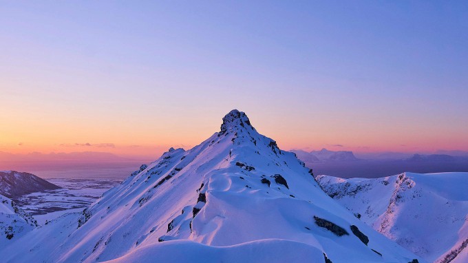 snowy mountain peak with sunrise glow 2210x1243